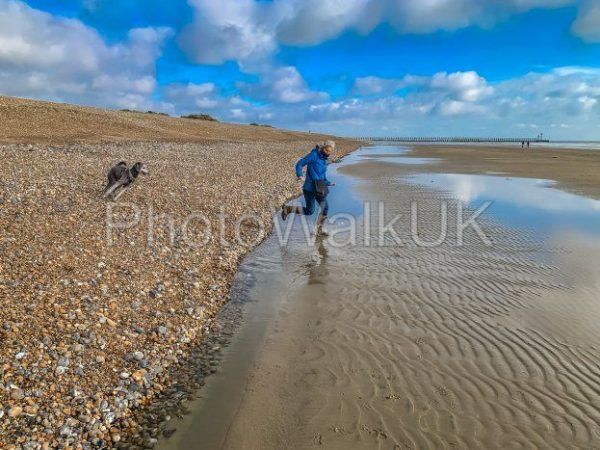 Woman Running on Beach with Young Poodle - Photo Walk UK