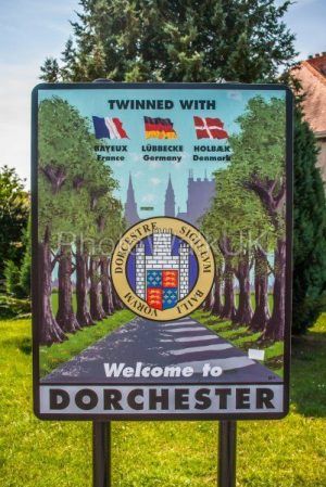 Welcome to Dorset Town Sign showing twinned cities Bayeux, Lubbecke and Holbaek - Photo Walk UK